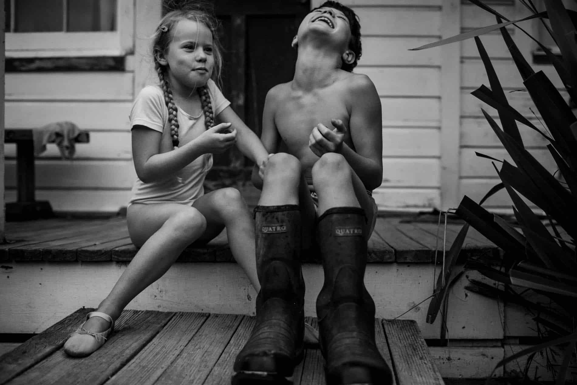 Black and white photo of a young girl and boy laughing together