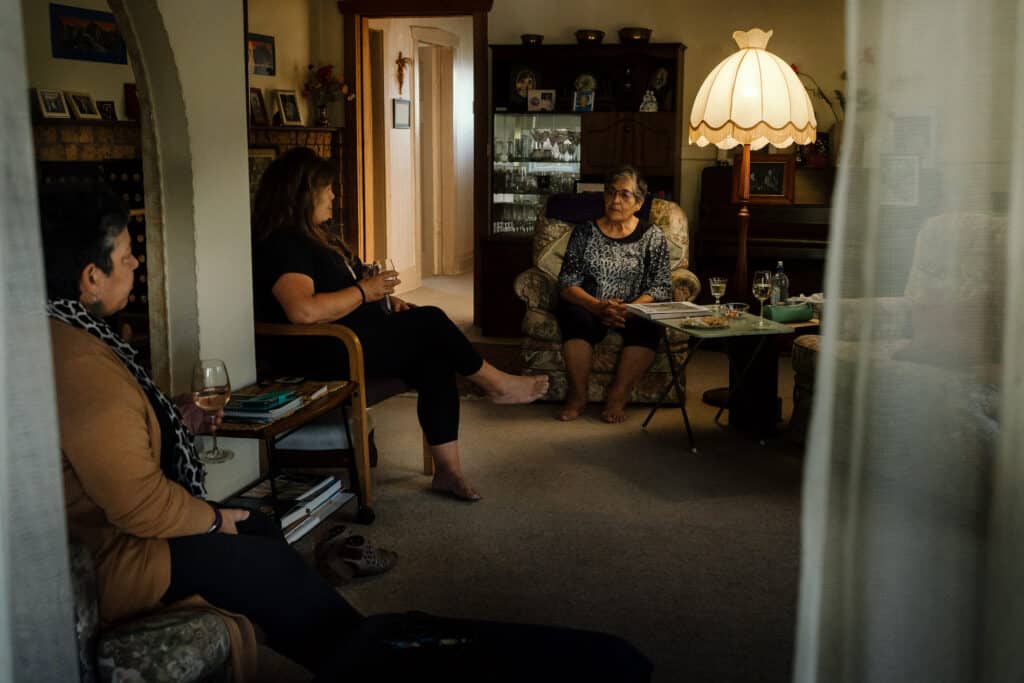 Mairangi and her two daughters sitting in the living room.