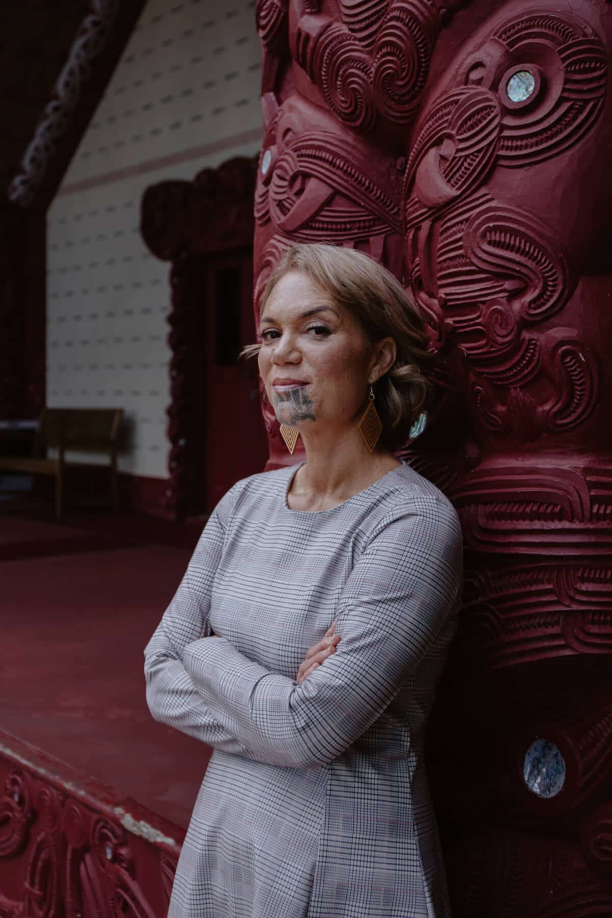 Māori woman standing inside a marae