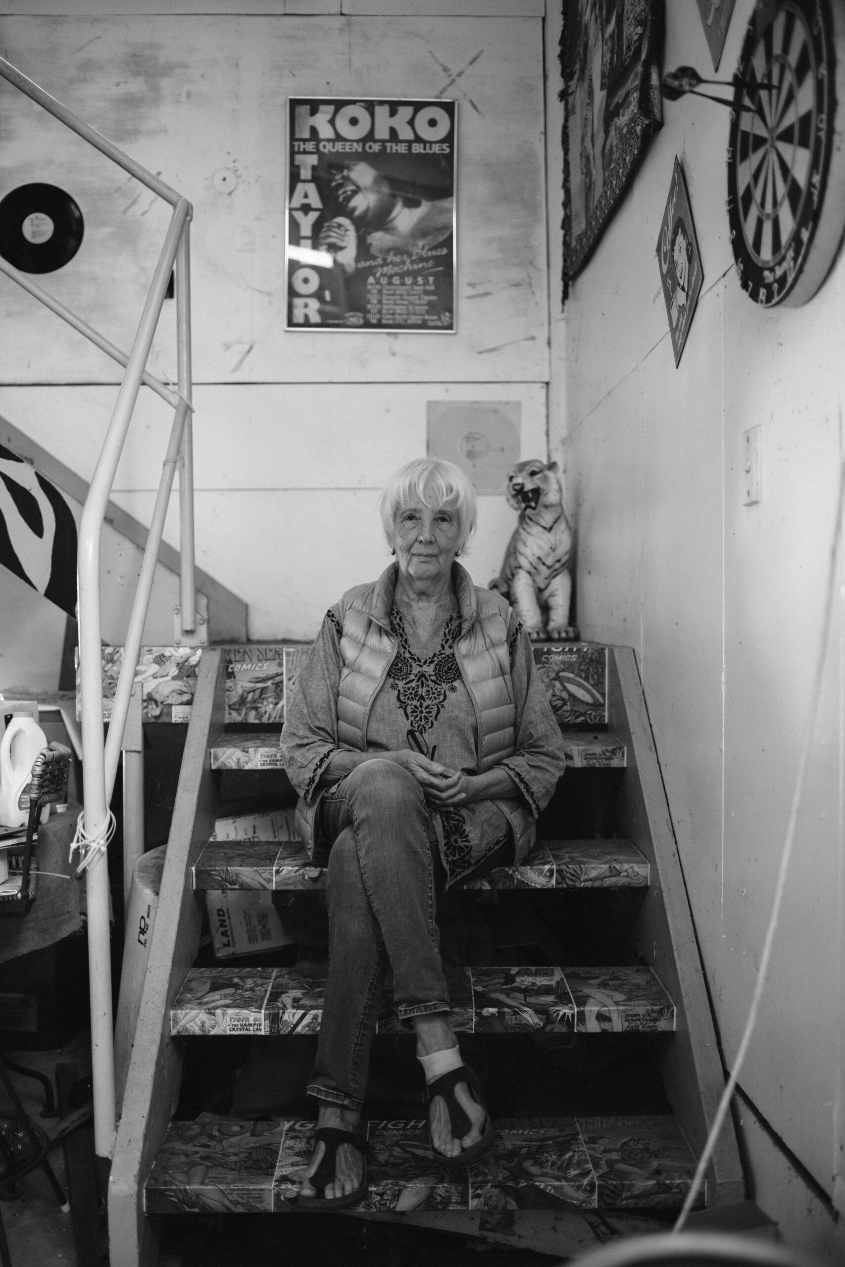 Anne on the stairs with a poster of American blues singer Koko Taylor on the wall
