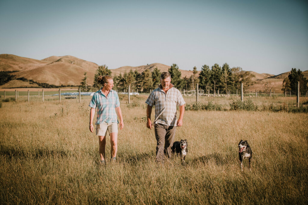 Two men and their dogs stand in a field
