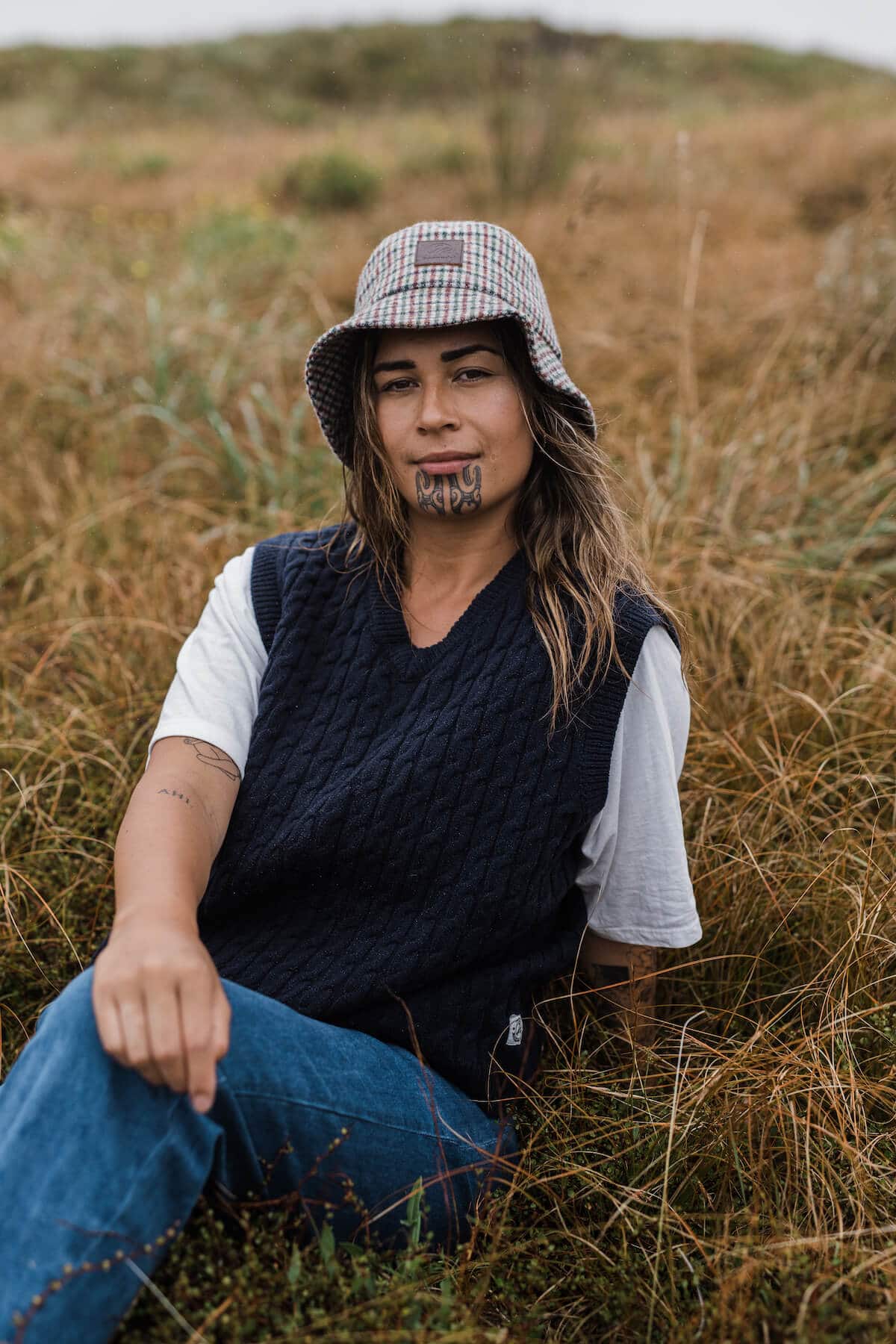 Arpége wearing the Kaimai Wool Bucket Hat in Society Check, $59.99, St. Ives Vest in Navy, $139.99, a borrowed white T-shirt and her own denim.