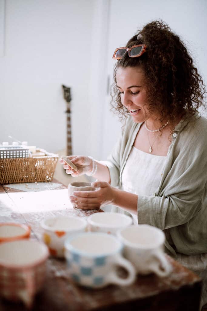 Bella making clay cups