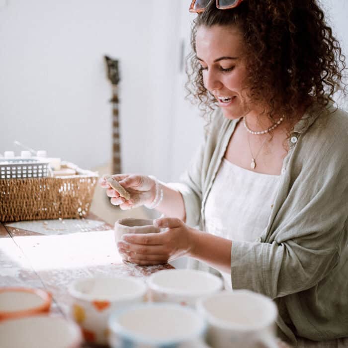 Bella making clay cups