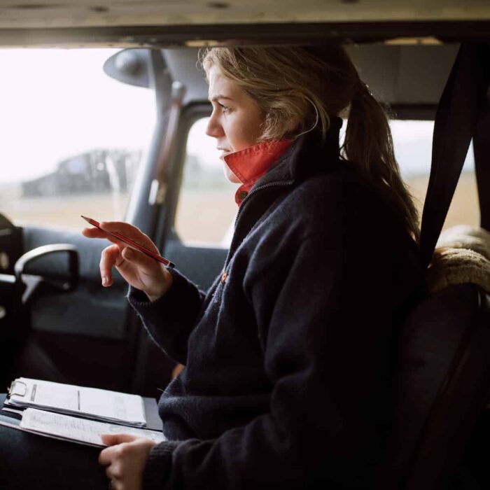 Woman sits in the cockpit of a small plane as she takes notes