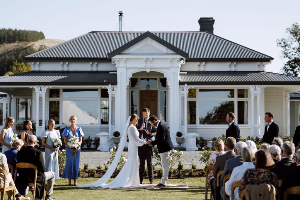 A couple getting married in front of an historic homestead.