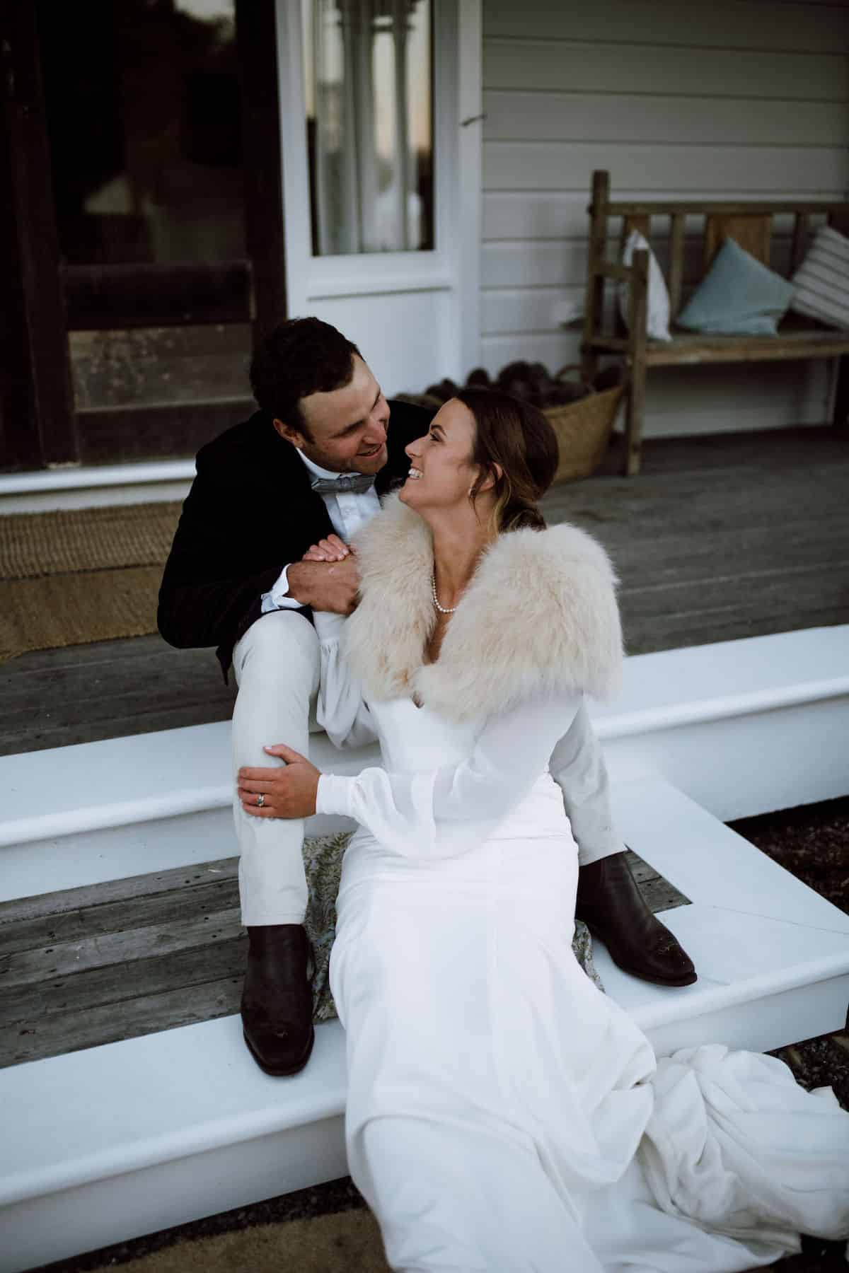 Newlywed couple smile at each other.