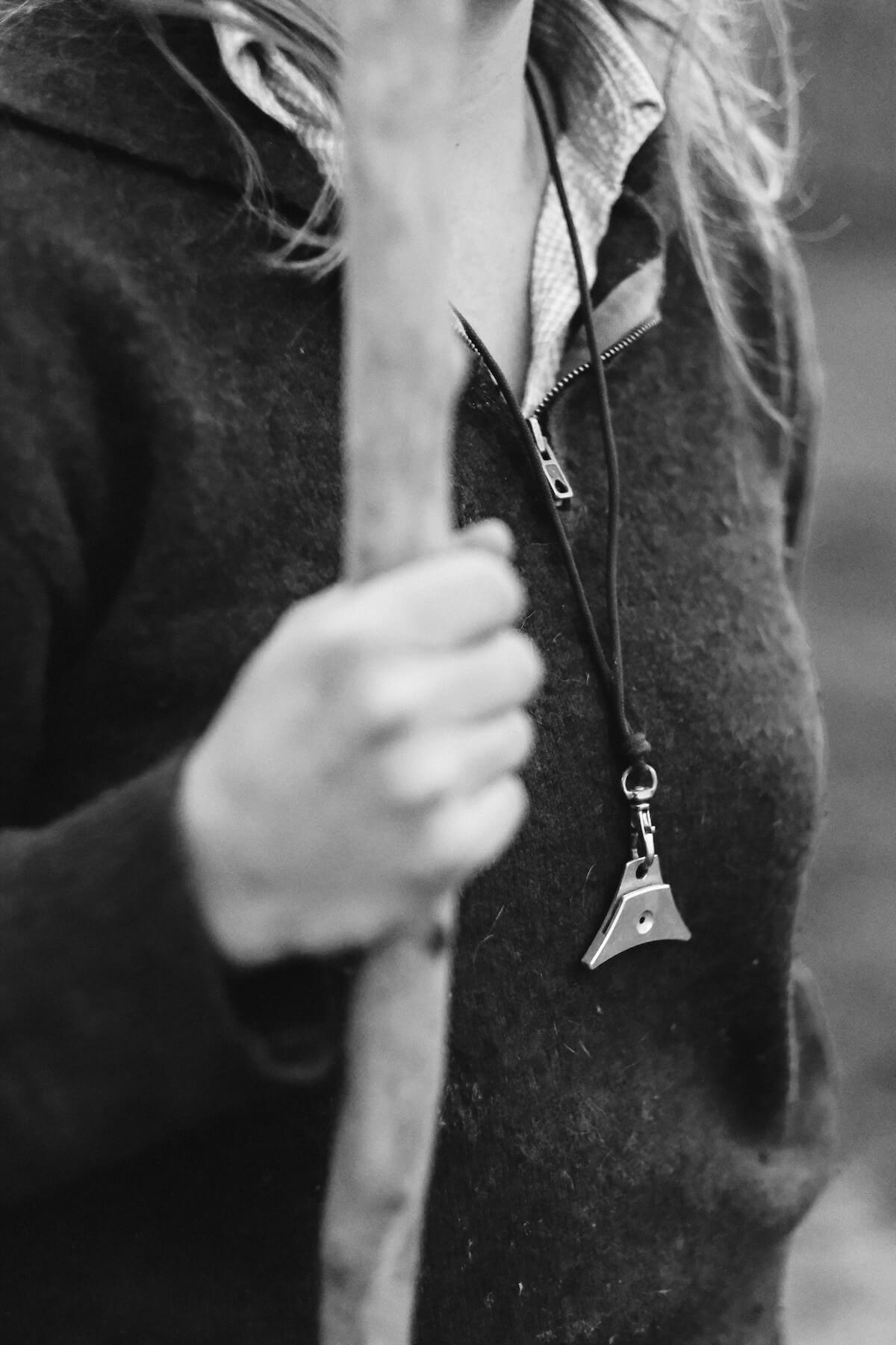Black and white close-up image of a shepherd's whistle hanging around Hannah's neck.