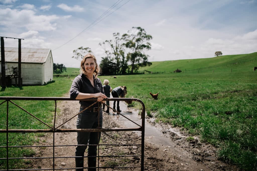 Woman stands at farm gate