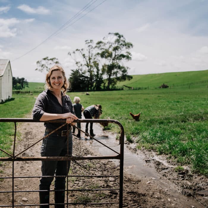 Woman stands at farm gate