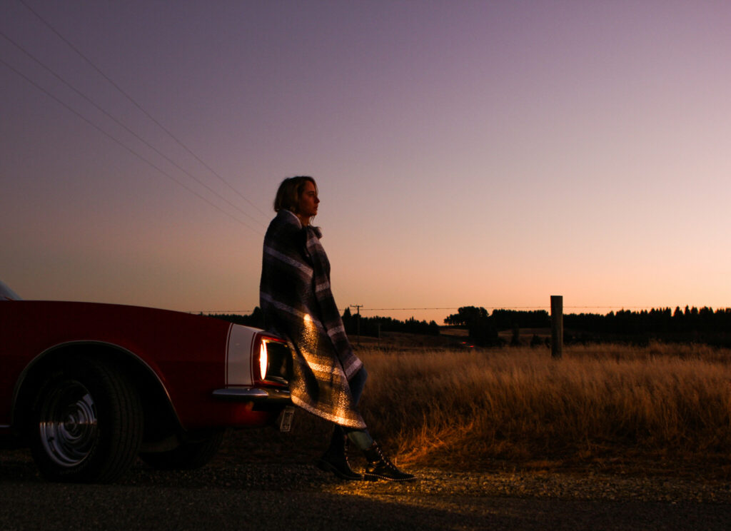 Kaylee Bell in front of a car
