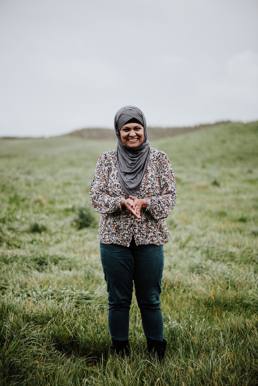 Woman standing in a paddock smiling at the camera.