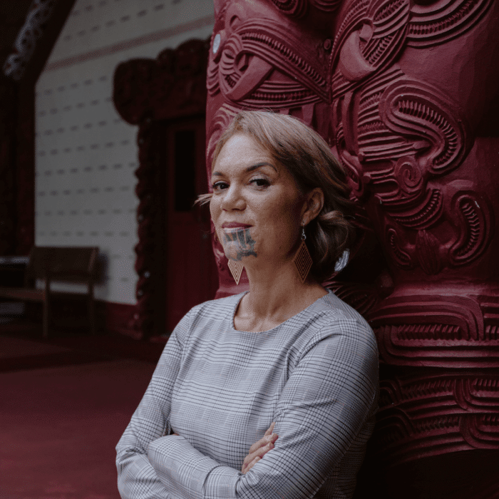 Māori woman standing inside a marae