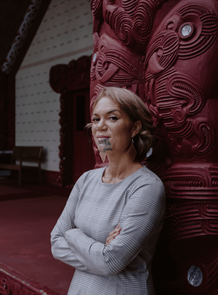 Māori woman standing inside a marae