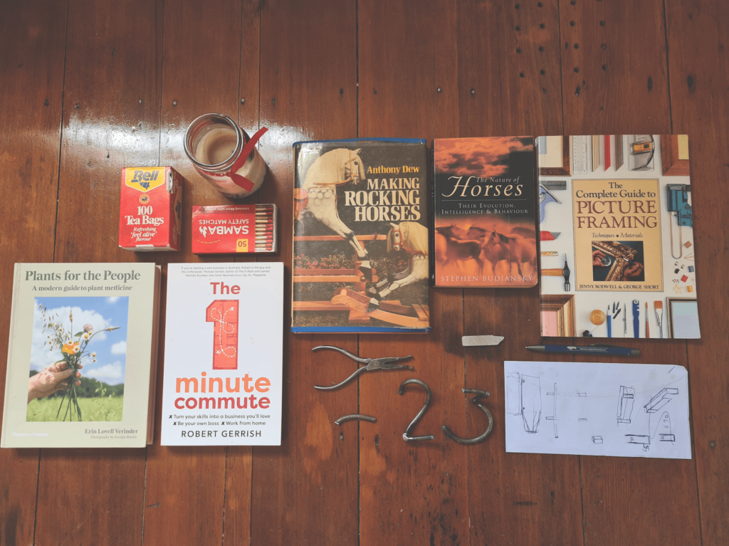 Flat lay image of assorted books, small sculptures and bric-a-brac found on Sharon's bedside table.