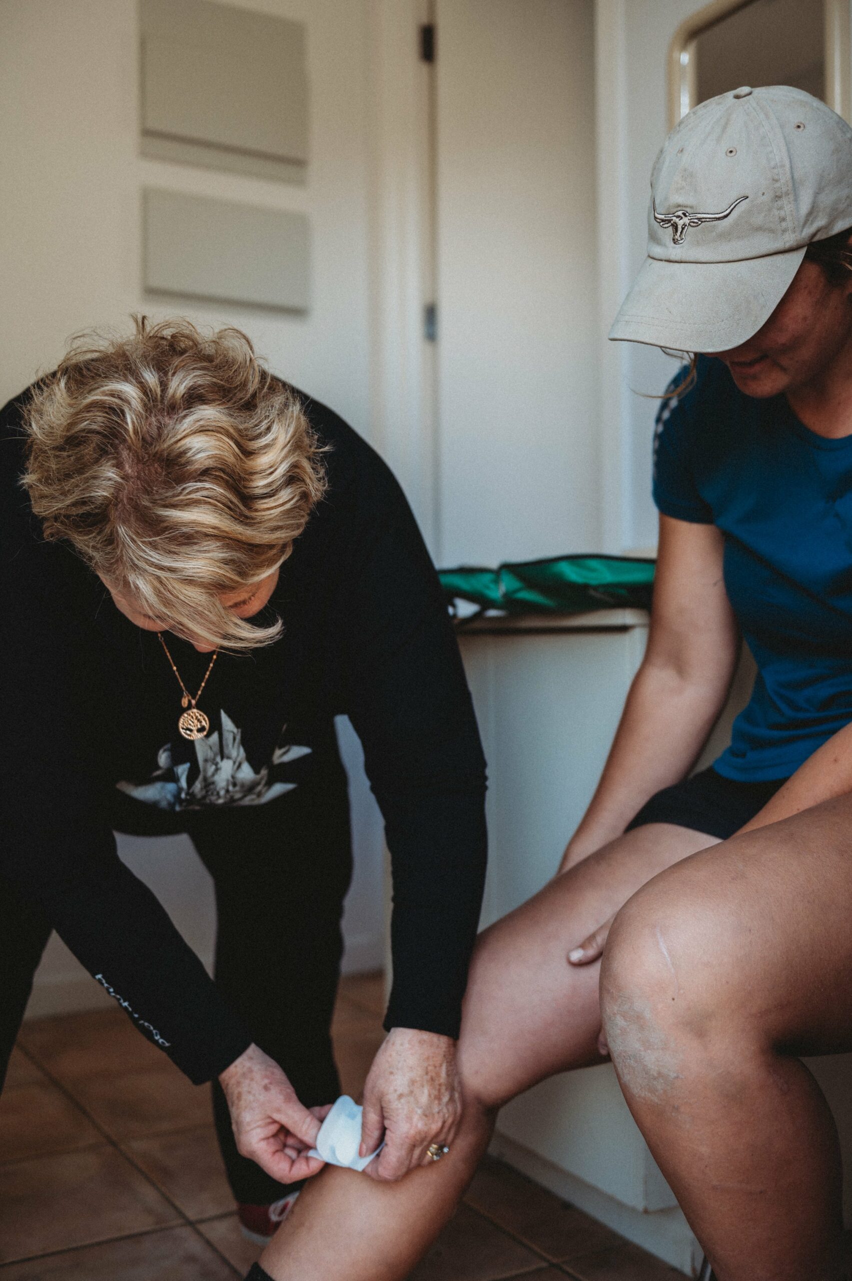 Heather bandages Olivia's knee, putting her first-aid skills to use.