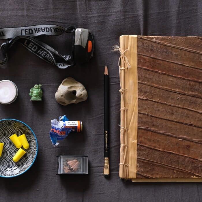 A sketchbook, pencil and miscellaneous bedside table items all laid out.