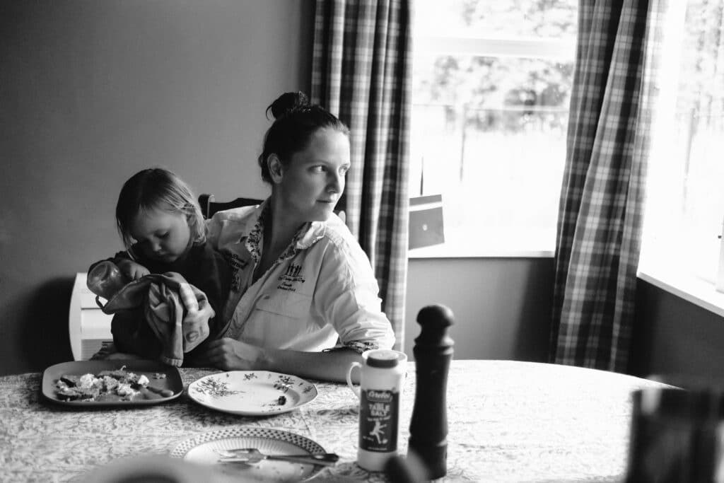 Kristy at her dining table with daughter Tully on her lap.