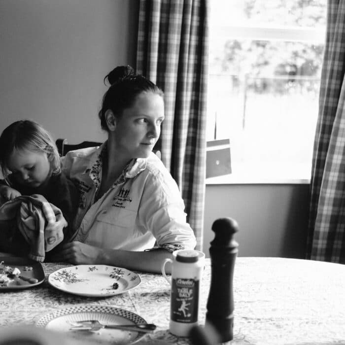 Kristy at her dining table with daughter Tully on her lap.