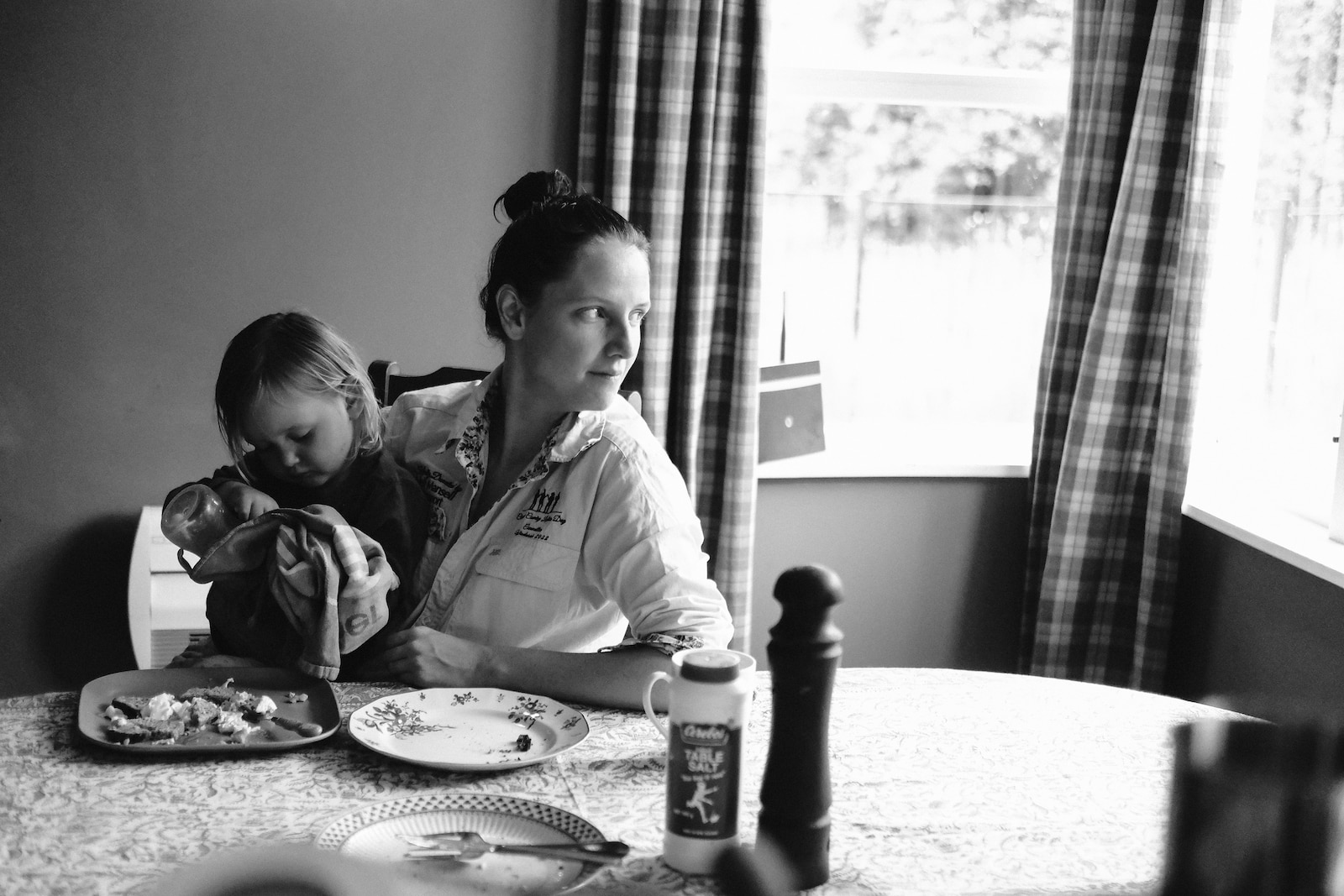 Kristy at her dining table with daughter Tully on her lap.