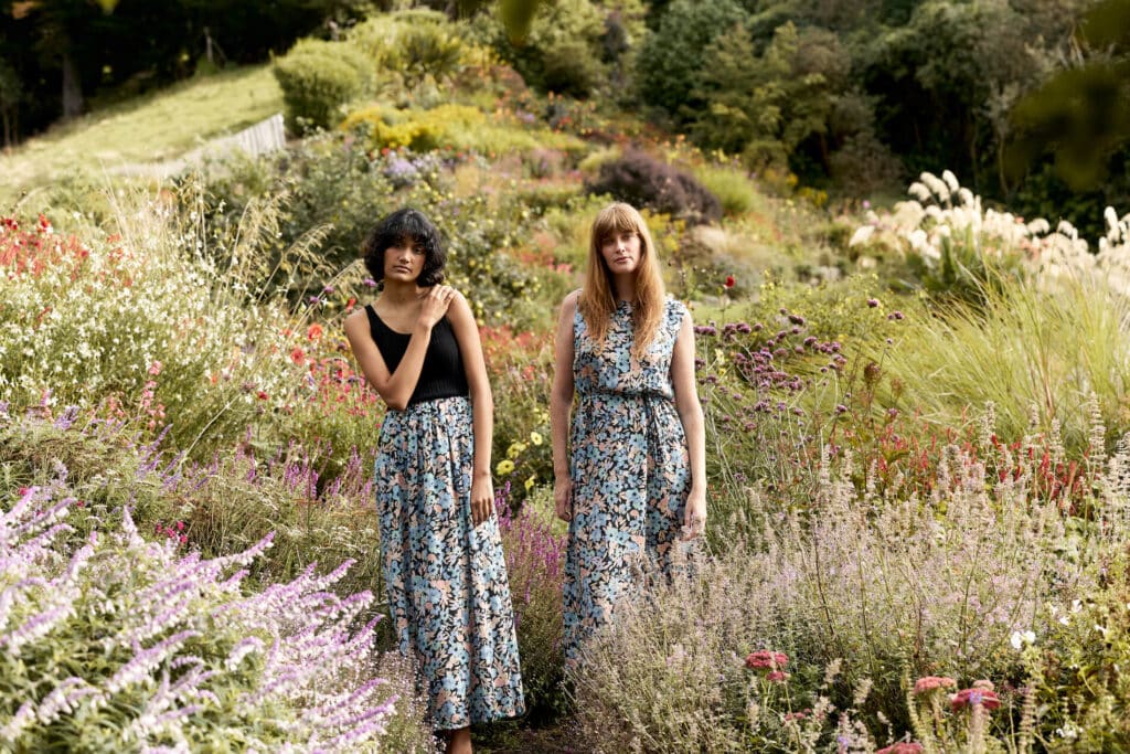 Two women standing in a field of wildflowers.