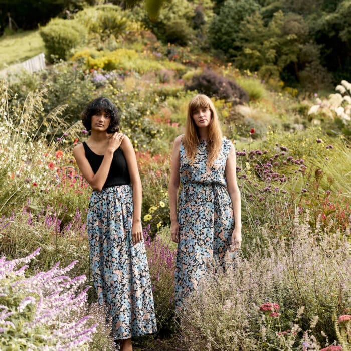 Two women standing in a field of wildflowers.