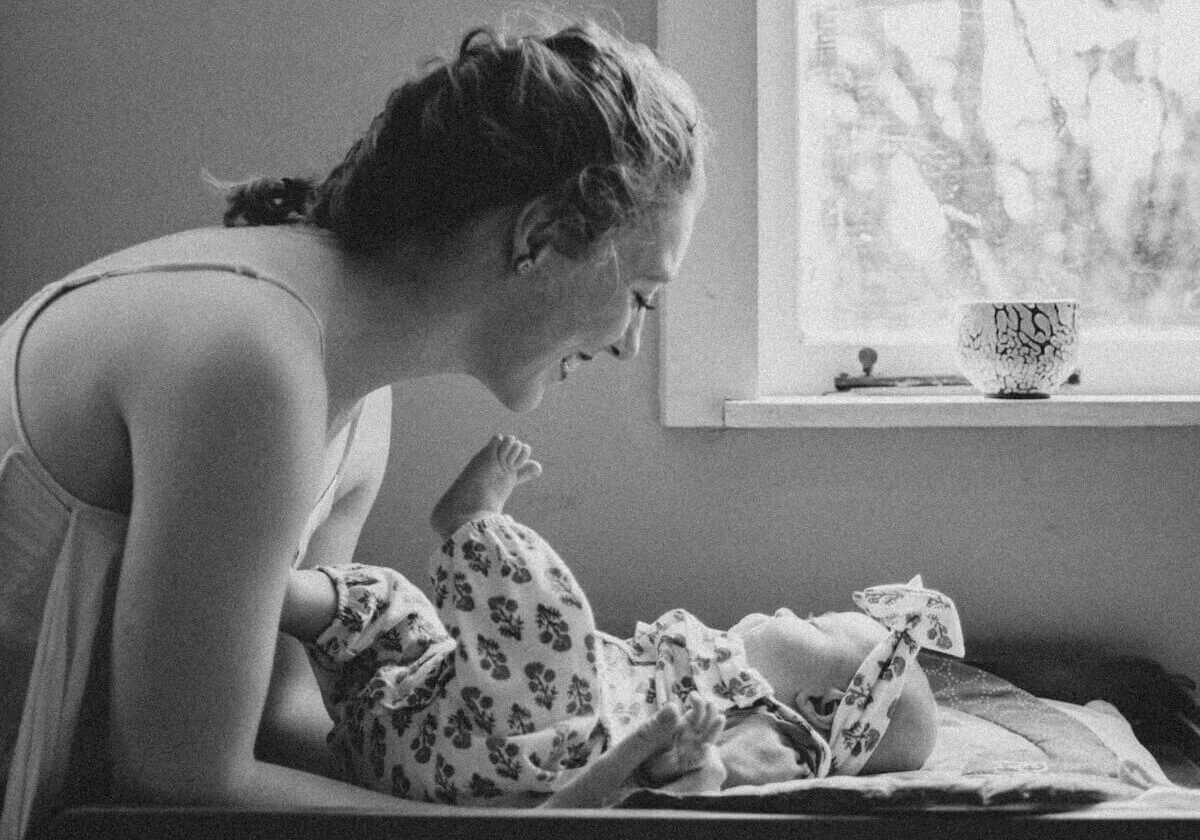 Blacka and white image of Eloise having a cuddle with her baby.