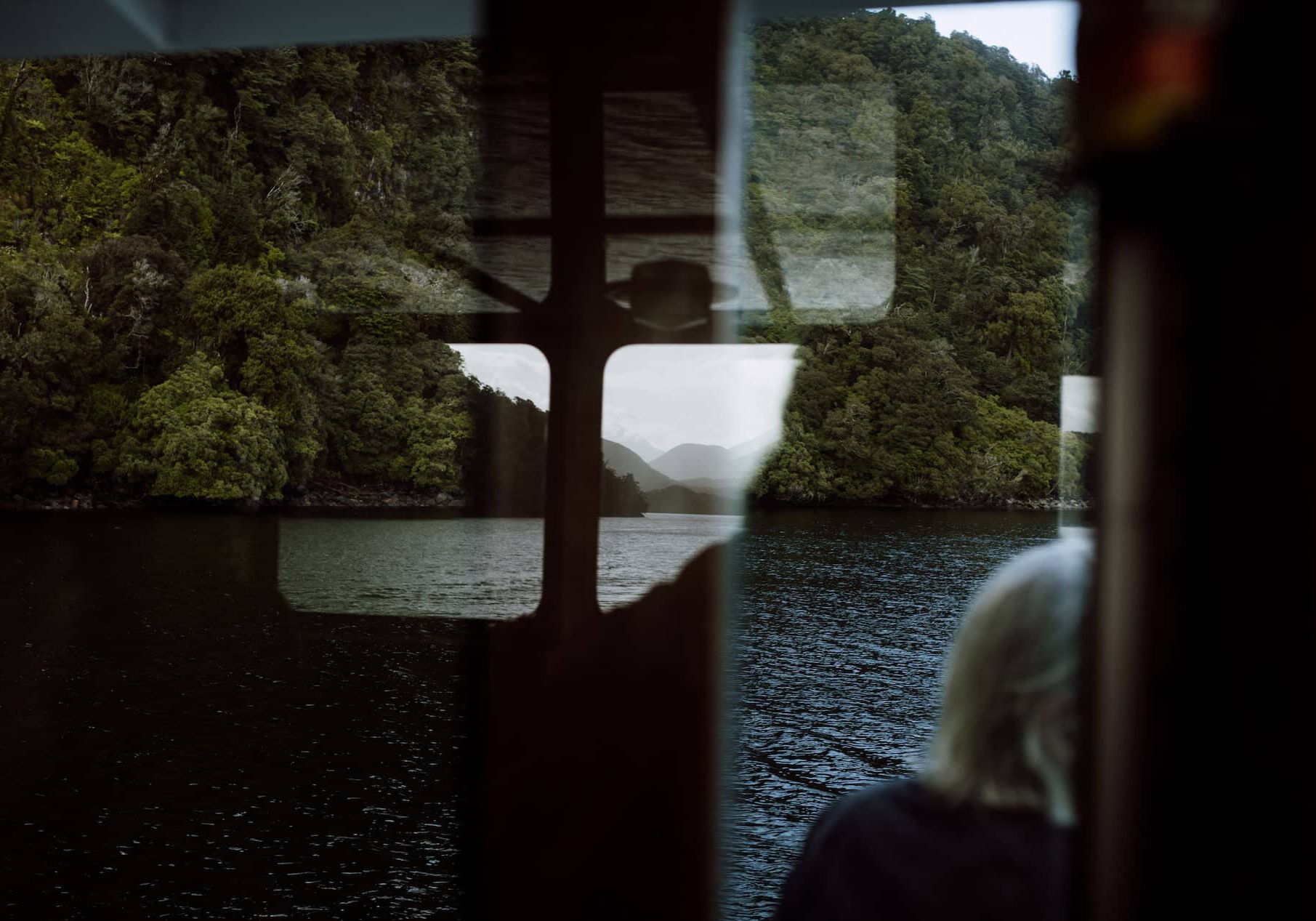 Tamatea Dusky Sound reflected in the window of the wheelhouse of the MV Flightless.