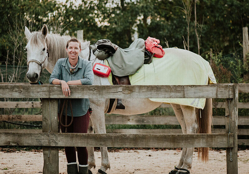 Larissa standing in front of a horse