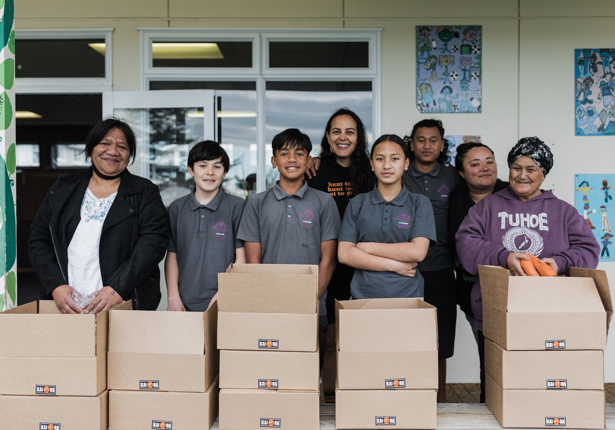 Tui with the Kura whānau preparing Kai Ora boxes to be delivered to whānau. From front left, Nanny Tira Nathan, Taurren Kupenga-Tamarama, Mana Biddle-Nepia, Hiria Whati-Haapu, Nanny Mere Teepa. In the back row Tui, Kiki Wilson and Māmā Karol Johnson.