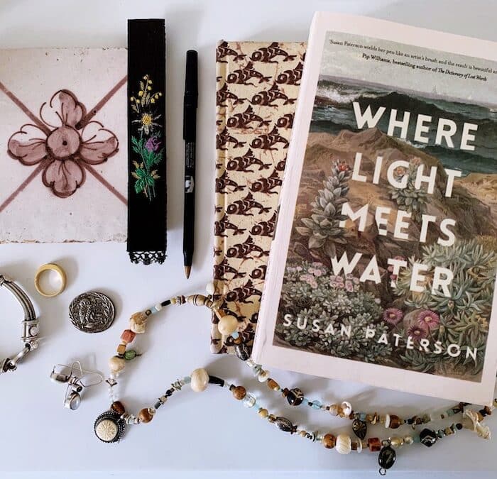 Books, jewellery and miscellaneous bedside table items laid out.