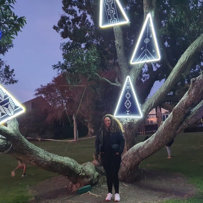 Woman in front of artwork in tree