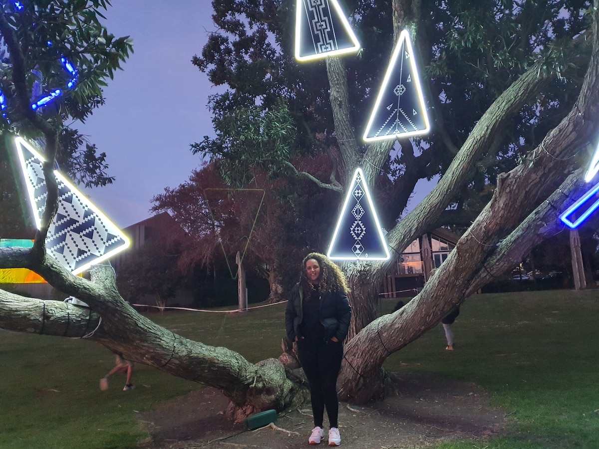 Woman in front of artwork in tree