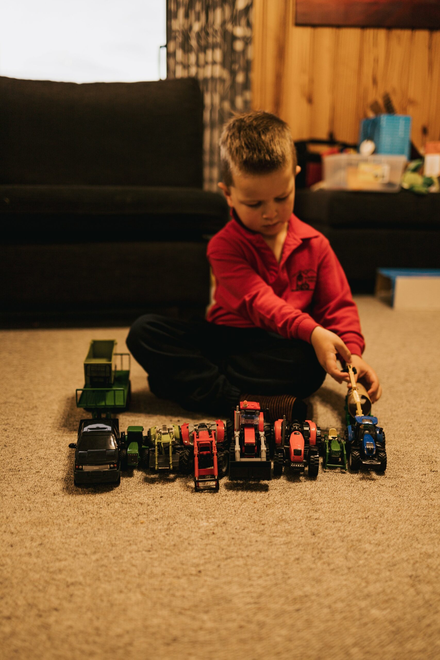Alexander plays with his toy tractors