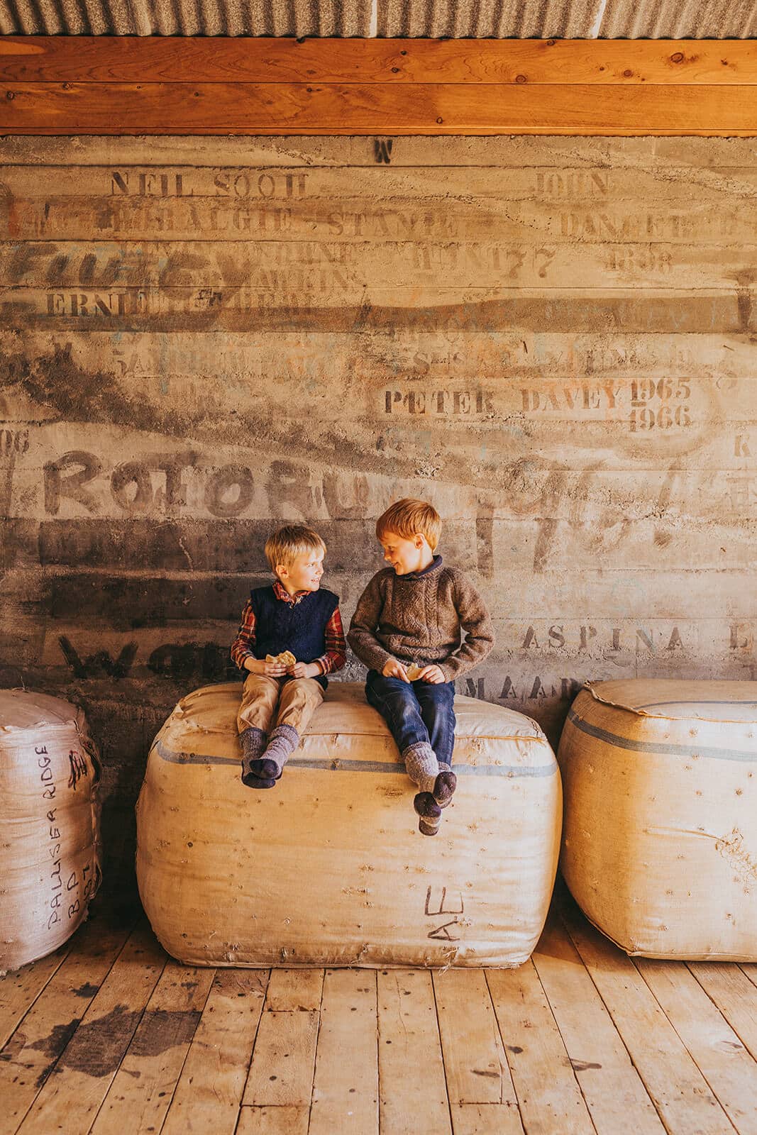 Two young boys sitting on wool bales