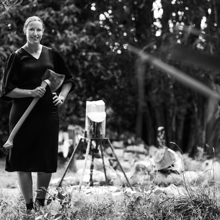 Black and white image of a woman holding an axe