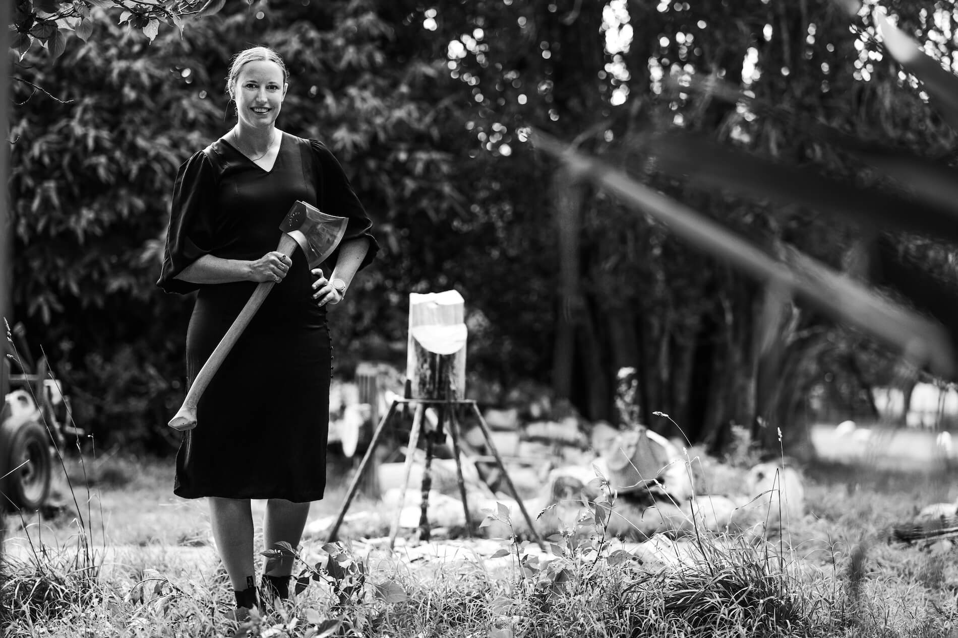 Black and white image of a woman holding an axe