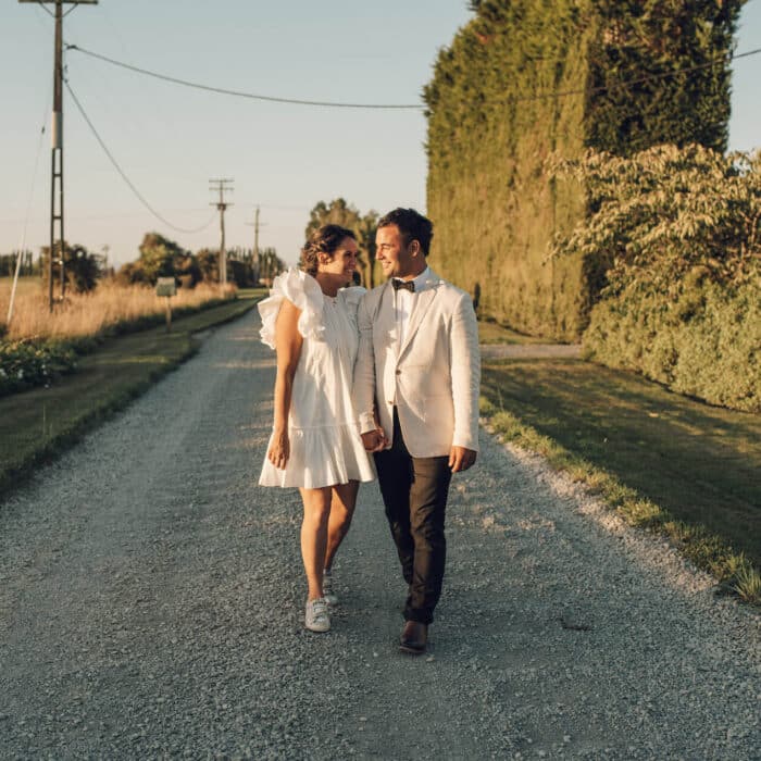 Newly married walk down a country road